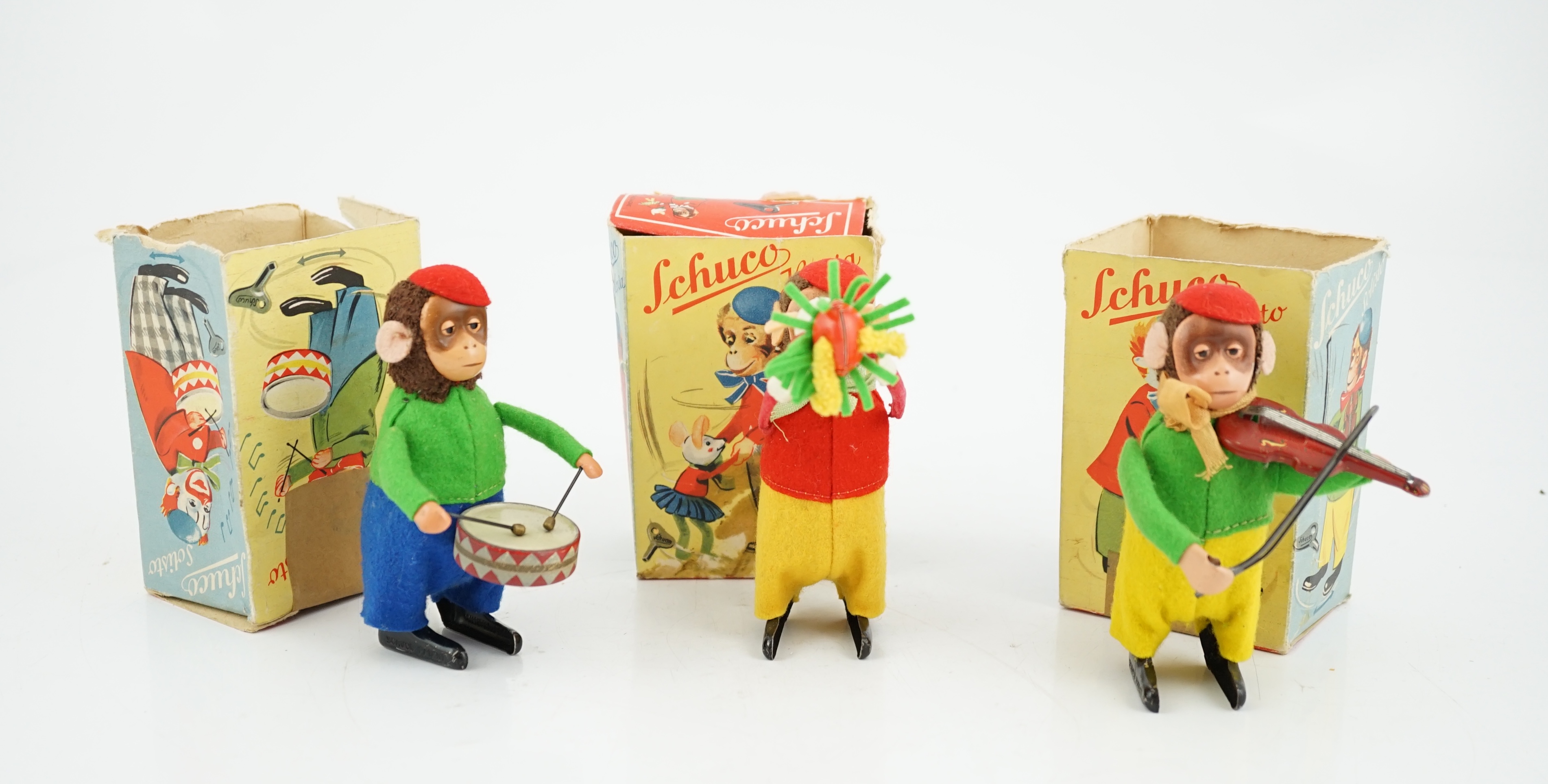 Three Schuco tinplate and felt clockwork monkeys; Hopsa, Solisto and Sousto, all contained within the remains of their boxes, 11cm high